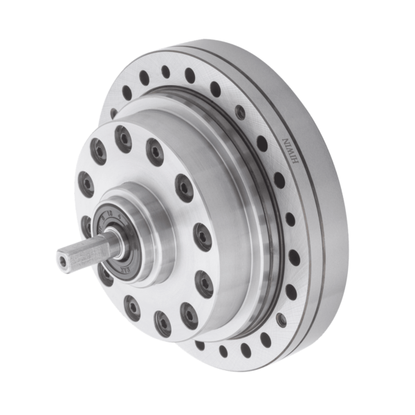 A close-up of a metallic harmonic drive gearbox with a cylindrical shape, multiple bolt holes, and a protruding shaft, shown against a plain white background.