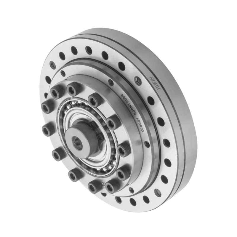 A close-up of a metallic circular mechanical component with multiple bolts, holes, and visible bearings, likely part of a precision industrial machine or robotics system, photographed on a white background.