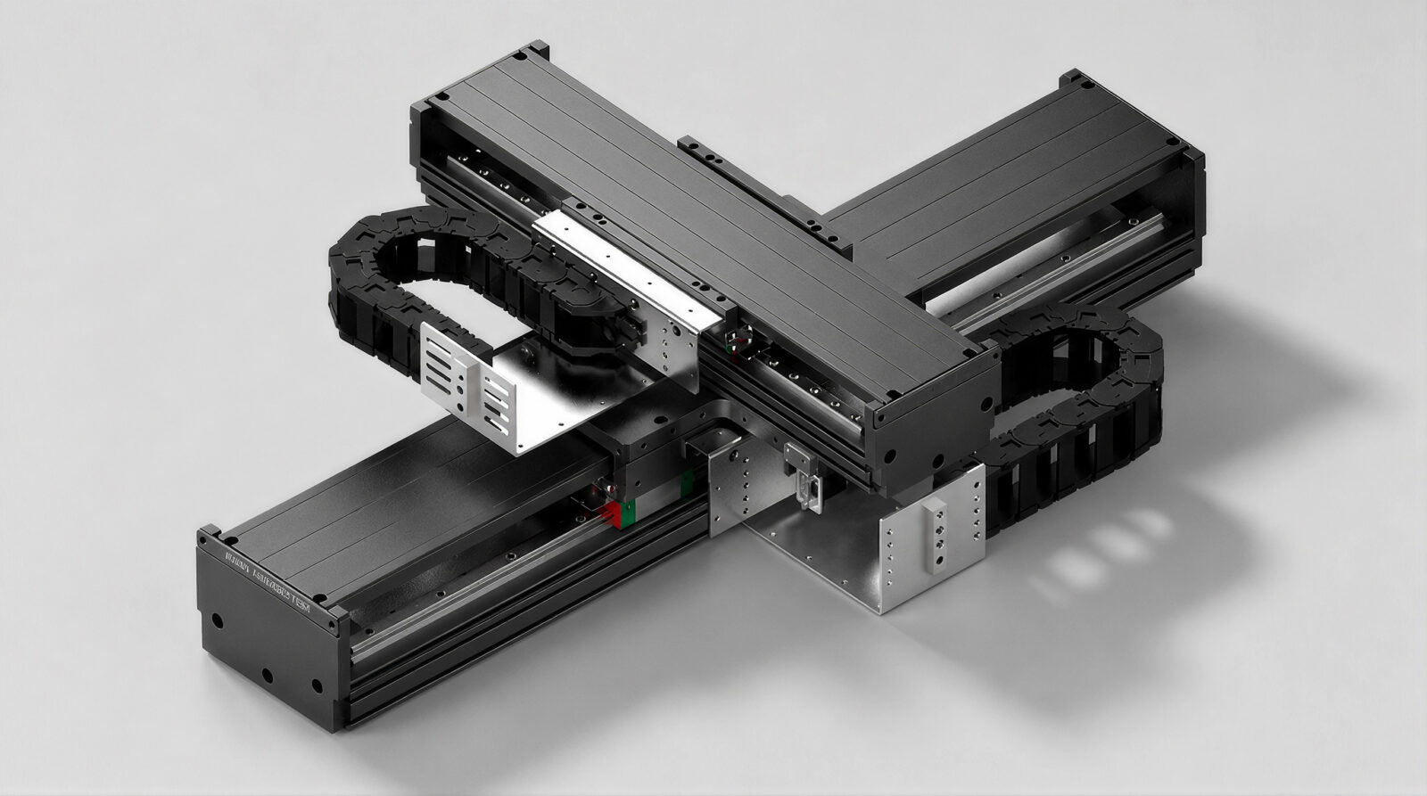 A black and silver industrial linear actuator system with three axes arranged in an X-Y-Z configuration, featuring cable carriers and metallic rails, on a light gray background.